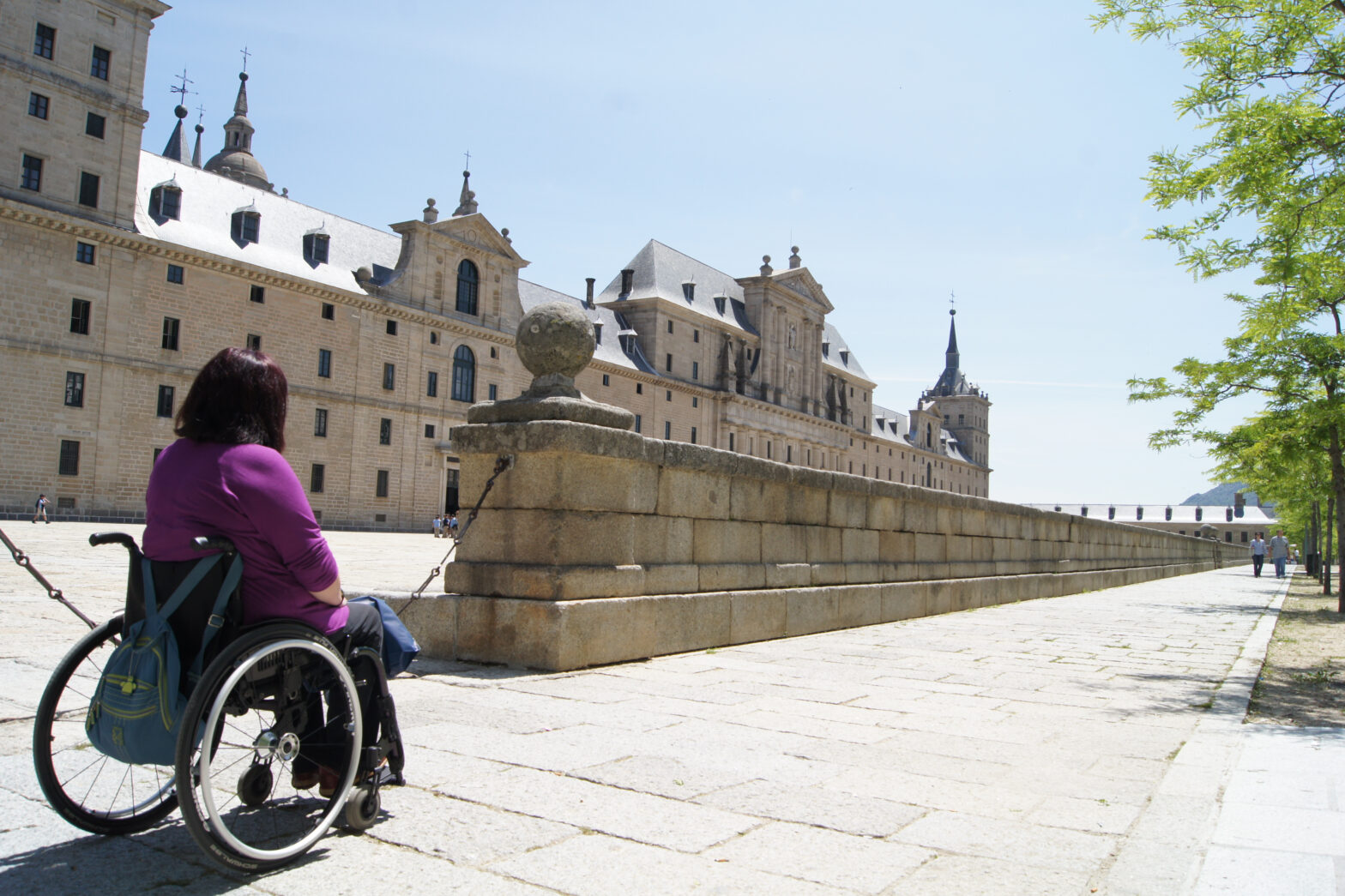 A wheelchair user outside The Escorial heritage building, Spain